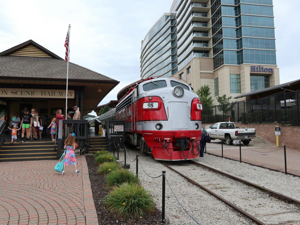 A classic locomotive at Branson Scenic Railway station with tourists in Missouri.