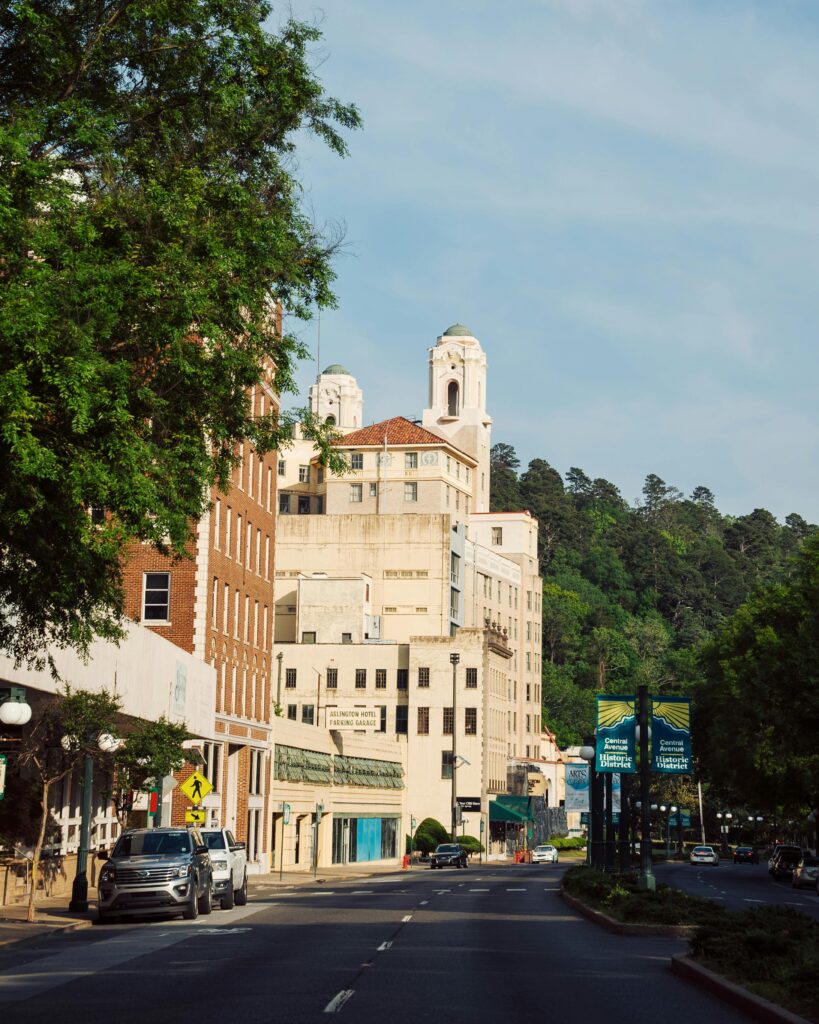 Charming urban street scene featuring historic buildings and lush greenery under a clear sky.