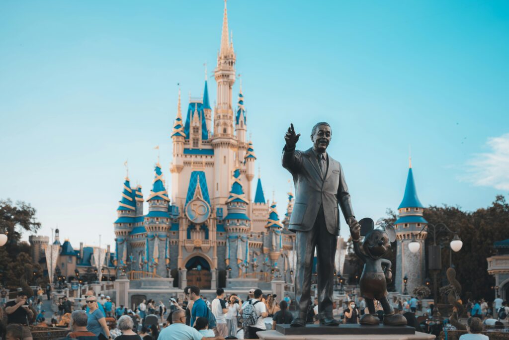 View of the iconic Cinderella Castle at Walt Disney World in Orlando, Florida, with crowd and statue.