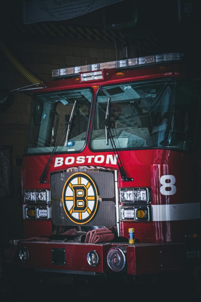 A Boston firetruck featuring a sports emblem parked inside a station, showcasing readiness.