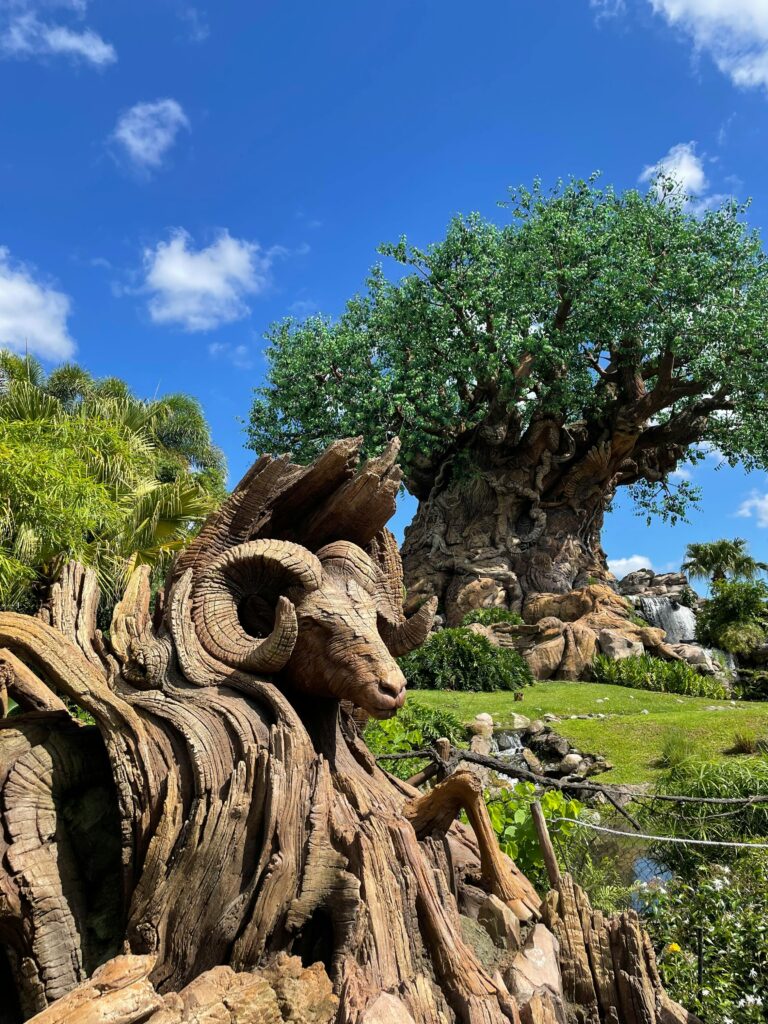 Stunning view of the Tree of Life sculpture under a bright blue sky at a park in Orlando, Florida.