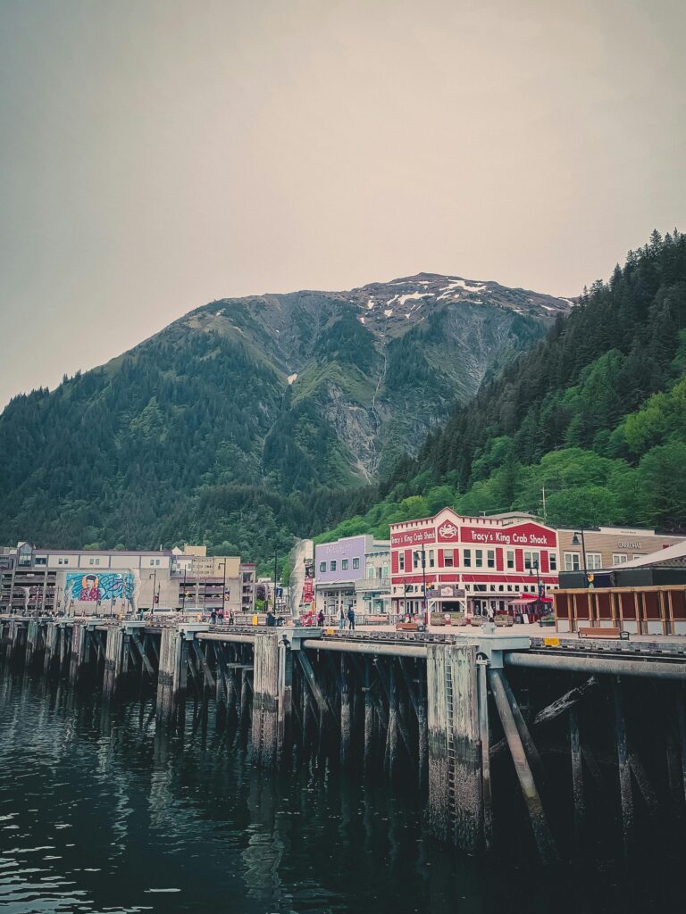 Picturesque view of Juneau's waterfront with lush mountains and colorful buildings.