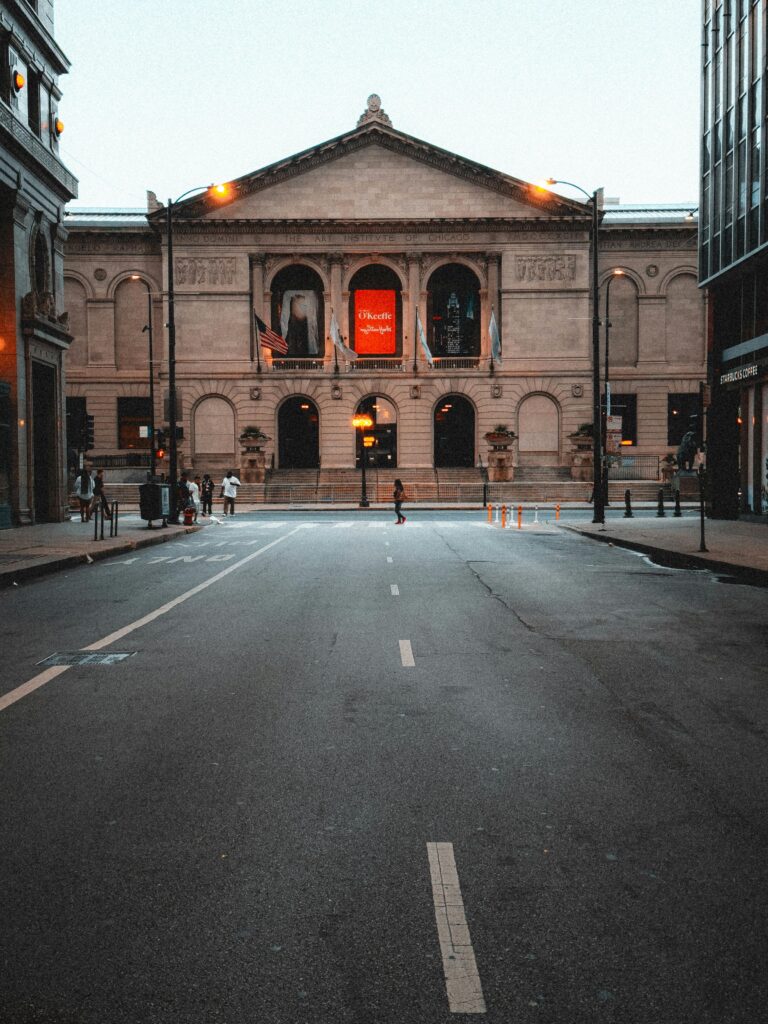 Dramatic view of the Art Institute of Chicago at dusk, featuring an empty street.