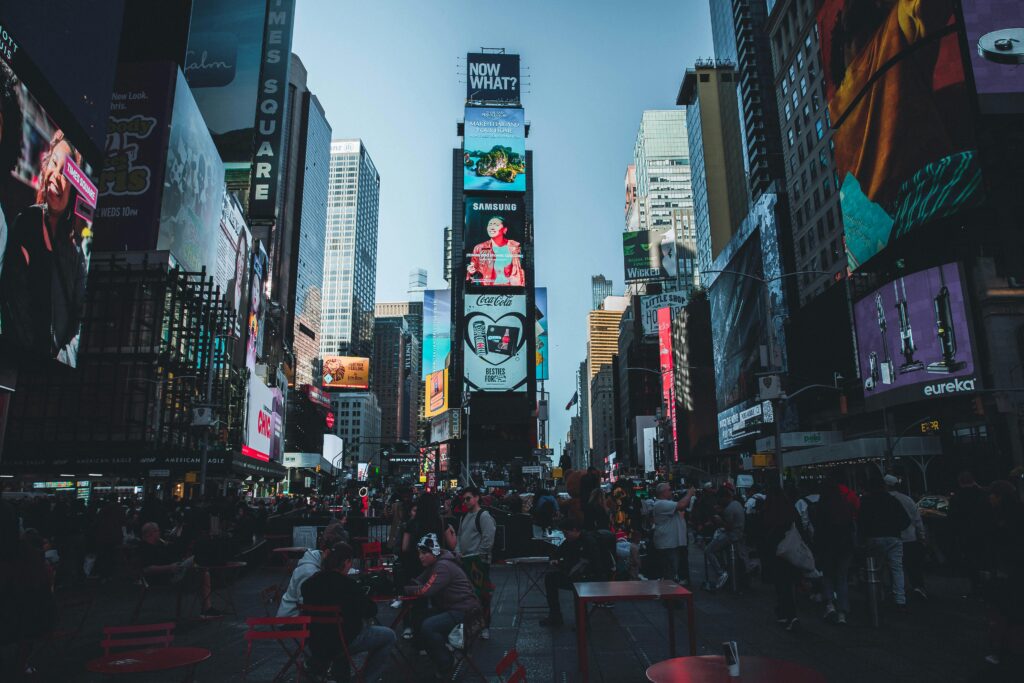 Vibrant Times Square in New York City filled with people and bright billboards during the day.