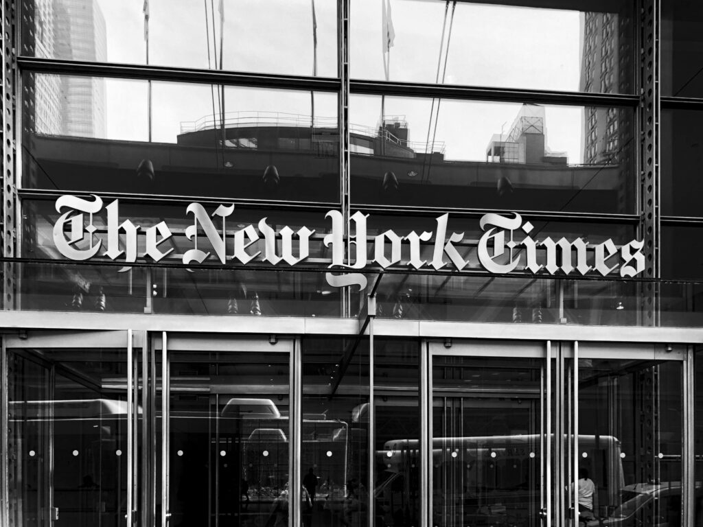 Grayscale image of The New York Times building entrance in New York City.