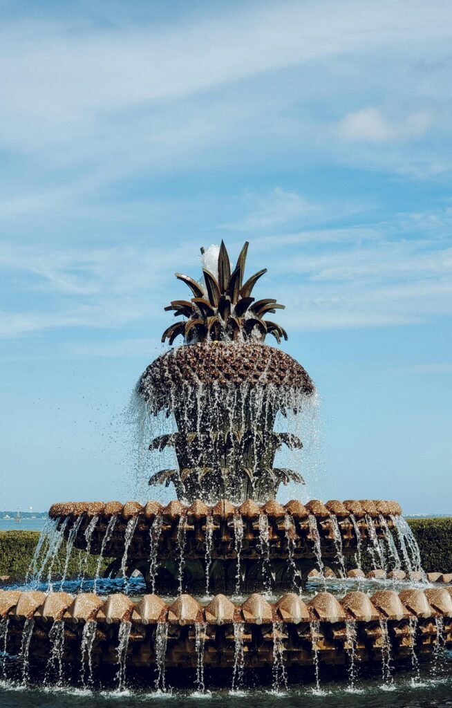 A beautiful view of the iconic Pineapple Fountain with clear blue skies in Charleston's Waterfront Park.